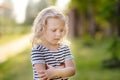 Upset or offended little girl standing on street of small town`s or village`s. ÃÂ¡risis of three years