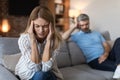 Upset offended mature european husband ignores wife, lady suffers from headache in living room interior