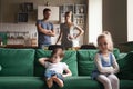 Upset offended sister, daughter sitting on couch with brother Royalty Free Stock Photo