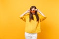 Upset offended young woman in fur sweater, white pants holding heart orange glasses looking aside isolated on bright Royalty Free Stock Photo