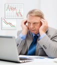 Upset older businessman with laptop in office Royalty Free Stock Photo