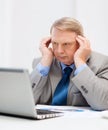 Upset older businessman with laptop in office Royalty Free Stock Photo