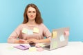 Upset overworked woman employee in nerd eyeglasses sitting at workplace office, all covered with sticky notes