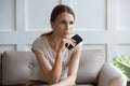 Upset pensive woman holding phone, waiting for call, feeling lonely