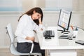 Upset Pregnant Woman Sitting At Computer Desk