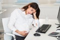 Upset Pregnant Woman Sitting At Computer Desk