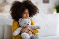 Upset preteen african american girl embracing teddy bear Royalty Free Stock Photo