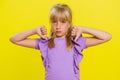 Upset preteen child girl showing thumbs down, dislike bad work, disapproval, dissatisfied feedback Royalty Free Stock Photo