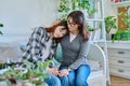 Upset sad hugged mother and daughter teenager sitting together on couch at home Royalty Free Stock Photo