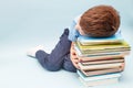 Upset schoolboy sitting with pile of school books. boy sleeping on a stack of textbooks Royalty Free Stock Photo