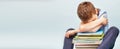 Upset schoolboy sitting with pile of school books and covers his face with hands. boy sleeping on a stack of textbooks Royalty Free Stock Photo