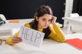 Upset schoolgirl holding paper with help