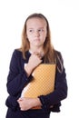 Upset schoolgirl in uniform and books looking aside