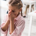 Upset schoolkid near table crying in