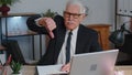 Upset senior business man showing thumbs down sign gesture, disapproval, dissatisfied, dislike Royalty Free Stock Photo