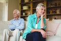 Upset senior couple ignoring each other in living room Royalty Free Stock Photo