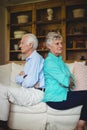 Upset senior couple ignoring each other in living room Royalty Free Stock Photo