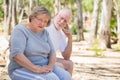 Upset Senior Woman Sits With Concerned Husband Outdoors