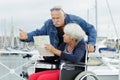 upset senior woman in wheelchair being pushed by husband Royalty Free Stock Photo