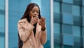 Upset shocked young woman standing outdoors receiving email on cellphone reading bad news sad distressed girl feels Royalty Free Stock Photo