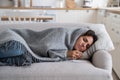 Upset sick woman tissue lying on couch at home got flu, having grippe symptoms, Royalty Free Stock Photo