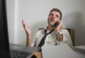 Upset and stressed businessman talking on phone at office desk - unhappy man working suffering stress as employee of corporate Royalty Free Stock Photo