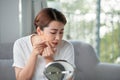Upset stressed sad acne woman with problem skin squeezes pimple at home using a small round mirror Royalty Free Stock Photo