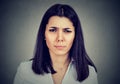 Upset stressed serious woman having headache frowning looking at camera