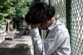 Upset stressed young Asian business man sitting on stairs and suffering from severe depression. Unemployment and layoff concept Royalty Free Stock Photo