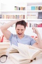 Upset student with hand on his head surrounded by books