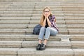 Upset student sitting on stairs outdoors