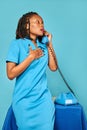 Upset surprised excited african american woman secretary calls on the phone. blue background Royalty Free Stock Photo