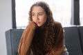 Upset teen girl sitting indoors reflecting boredom, portrait shot