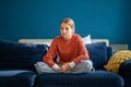 Upset teen girl sitting on sofa at home feeling lonely and frustrated Royalty Free Stock Photo