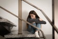 Upset teenage girl sitting on stairs indoors Royalty Free Stock Photo