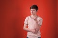 Upset teenager in beige t shirt standing with hand on waist and looking away Royalty Free Stock Photo