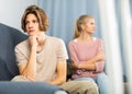 Upset teenager sitting on sofa after quarrel with mother Royalty Free Stock Photo