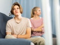 Upset teenager sitting on sofa after quarrel with mother Royalty Free Stock Photo