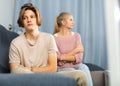 Upset teenager sitting on sofa after quarrel with mother Royalty Free Stock Photo