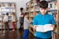 Upset tween boy browsing book Royalty Free Stock Photo