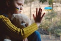 Upset Ukrainian little girl child holding fluffy beard sitting alone at windowsill. State support in war. United Europe against