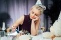 Upset, unhappy attractive woman eating festive cake while celebrating birthday at home, sitting alone at served table