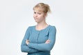 Upset unsatisfied blonde woman standing with arms folded