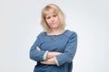 Upset unsatisfied blonde woman standing with arms folded