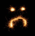 Upset weird sad smiley drawn with sparkles on black background Royalty Free Stock Photo