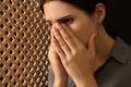 Upset woman covering face with hands and listening to priest during confession in booth, closeup Royalty Free Stock Photo