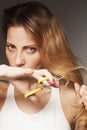 Upset woman cutting her her hair. Problem of split ends Royalty Free Stock Photo