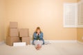 Upset Woman on Floor Next to Boxes and Blank Sign