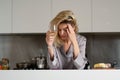 Upset woman have bad new. Depressed woman in the kitchen in the morning. Sad woman wearing pajama drink wine in home Royalty Free Stock Photo