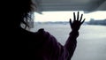 Upset woman looking through airport window at planes, saying goodbye to family Royalty Free Stock Photo